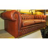 A traditional three seat chesterfield sofa with buttoned framework, upholstered in a mid-tan