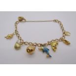 9ct curb link charm bracelet with heart padlock clasp, hung with seven novelty charms to include