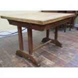 A arts and crafts style stripped oak draw leaf dining table of rectangular form, raised on square