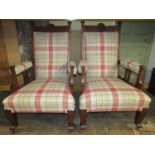 A pair of arts and crafts fireside chairs in walnut with recently reupholstered finish
