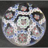 A Baccarat mid 19th century clear glass millefiori paperweight with rings of multi coloured cane and