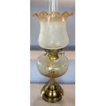 A 19th century oil lamp with flared pie crust shade and amber shaded font on a brass column