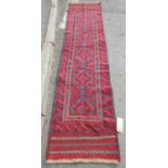 A Meshwani Runner with repeated central diamond design in tones of alizarin crimson, violet blue,