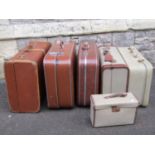 A collection of vintage luggage including a fibre and lathe bound example