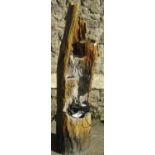 A contemporary composite cascading water feature in the form of a tree trunk, 122 cm high