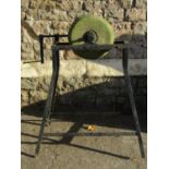 An old well-used sharpening stone on an iron stand with winding handle