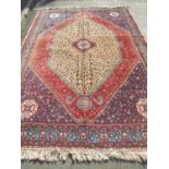 A Large Persian rug with an intricate design of dense floral, animal and symbolic motifs in tones of