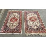 Pair of Persian rugs, each with central lobed medallion in madder on a natural wool ground,