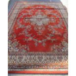A large Wilton Kashan wool carpet with a central floral medallion on a burnt orange ground, 364cm