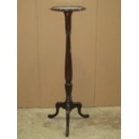 An Edwardian mahogany torchere in the Georgian style with circular tray top, raised on a turned