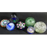 Seven paperweights of varying designs three with composite floret and star cane decoration, a tall