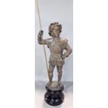 A gold finished spelter figure of a Yeoman holding a staff raised on a socle base. 51cm max.