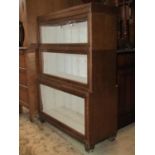 A Globe Wernicke style stained oak veneered freestanding three sectional bookcase enclosed by up and