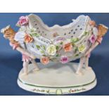 A German porcelain table centre a pierced basket, floral encrusted supported by two fairies, 38cm