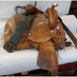 A large Western dressage Saddle, with floral tooled leather decoration and sheep skin lined,