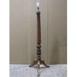 A mahogany standard lamp with rope twist and carved acanthus column raised on a swept tripod (