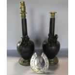 A pair of bronze elongated urn shaped table lamps with mounted cherubs and brass capitals, (as found
