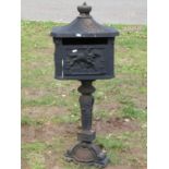 A reproduction cast iron freestanding post box with simulated tiled roof, crown finial, 1 metre high