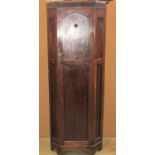 A 1920s oak floorstanding corner hall/bedroom wardrobe enclosed by a lancet shaped panelled door, 68