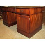 An office desk in the Georgian style with inset leather top over an arrangement of cupboards and