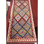 A Chobi Kilim Runner with geometric burdock diamond design and hooked border in multicoloured tones,