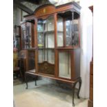 An Edwardian mahogany display cabinet, enclosed by a central partially glazed split moulded panelled