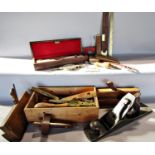 A collection of vintage tools, including planes, wooden routing tools, rulers, spirit levels, oil