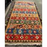 A South West Persian Qashquai Kilim with multi-coloured geometric design and tasseled selvages,