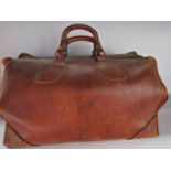 A vintage matured brown leather Gladstone bag, with working zip but fastening clasp broken off (in