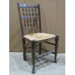 A set of four Lancashire style stained beechwood spindle back dining chairs with rush seats,