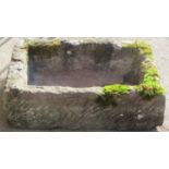 A weathered natural stone trough of rectangular form, 64cm long x 45cm wide x 18cm deep