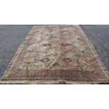 A Large Middle Eastern Rug with geometric design in neutral tones of brown, green and red, 320 x 240