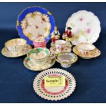 A collection of decorative tableware including lattice work plates, two figurines, Dresden cup and