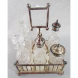 A silver plated Edwardian vinaigrette stand with six divisions complete with six glass bottles,