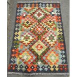 A Chobi kilim with intricate geometric design in multicoloured tones and a deep blue border, 124cm x