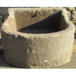 A weathered natural stone D shaped trough, 56cm wide x 54cm deep x 30cm high