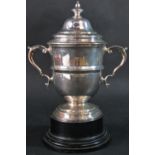 A silver two piece trophy cup with removable cup cover and two scrolled arms, no dedication,