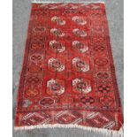 A Turkoman Tekke Rug with elephant foot design in mellow tones of orange, indigo and natural wool,