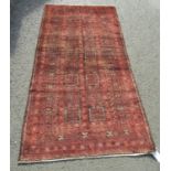 A North East Persian Turkoman rug with a central design of eighteen squares in deep tones of madder,