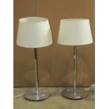 A pair of contemporary art deco style chrome table lamps with weighted disc bases