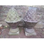 A pair of weathered cast composition stone pineapple pier cap finials 60 cm high approx, together