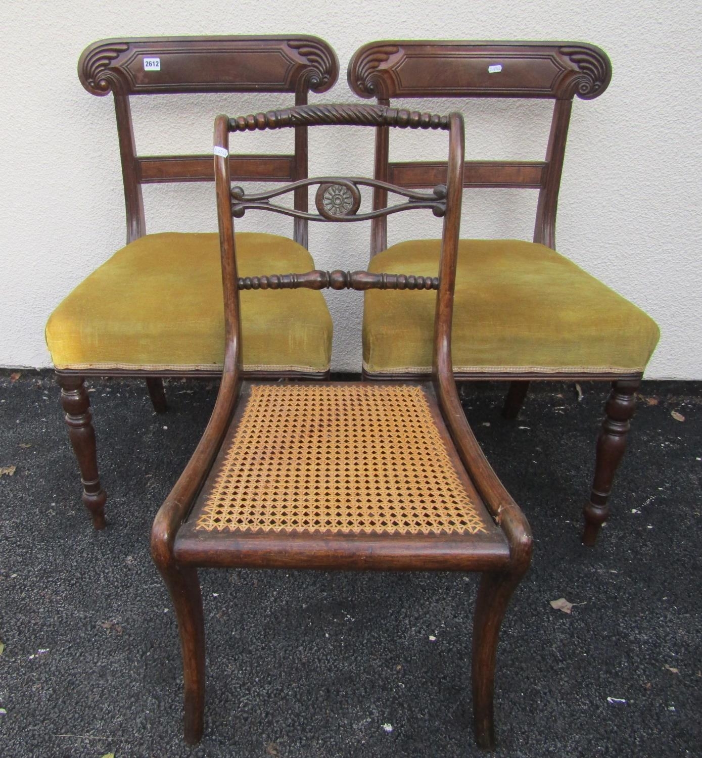 A pair of late regency mahogany dining chairs with carved splats and upholstered seats, plus one