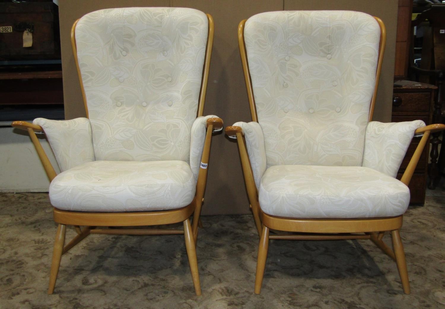 A pair of Ercol light beechwood framed Windsor style stick back armchairs with loose cushions