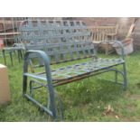 A green painted tubular steel framed two seat rocking garden bench with interlaced strapwork seat