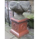 A weathered cast composition stone circular garden urn and combined socle with swag detail, raised