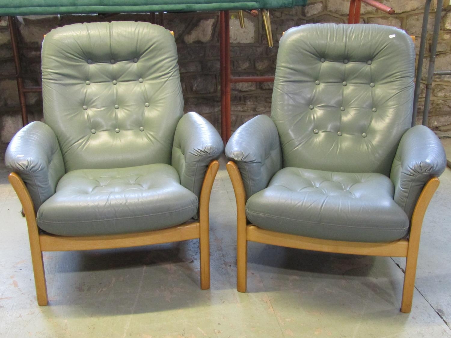 An Ercol three piece lounge suite comprising three seat sofa and pair of matching armchairs with