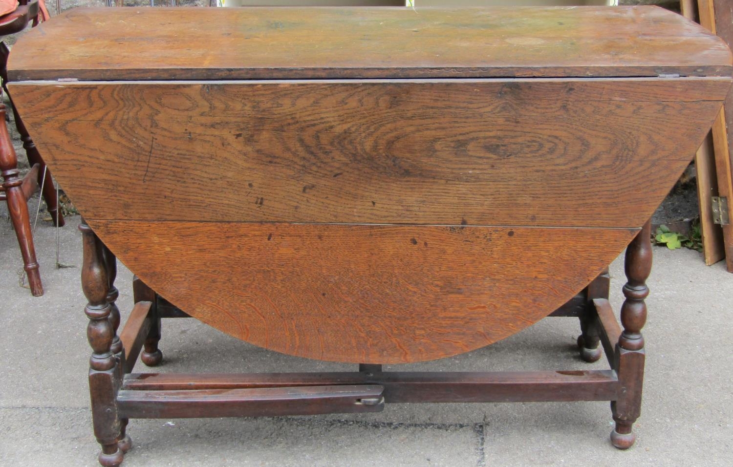 A Georgian oval drop leaf gateleg dining table, principally in oak, raised on six turned supports