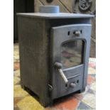 A small cast iron wood burning stove, 32 cm square approximately x 46 cm high