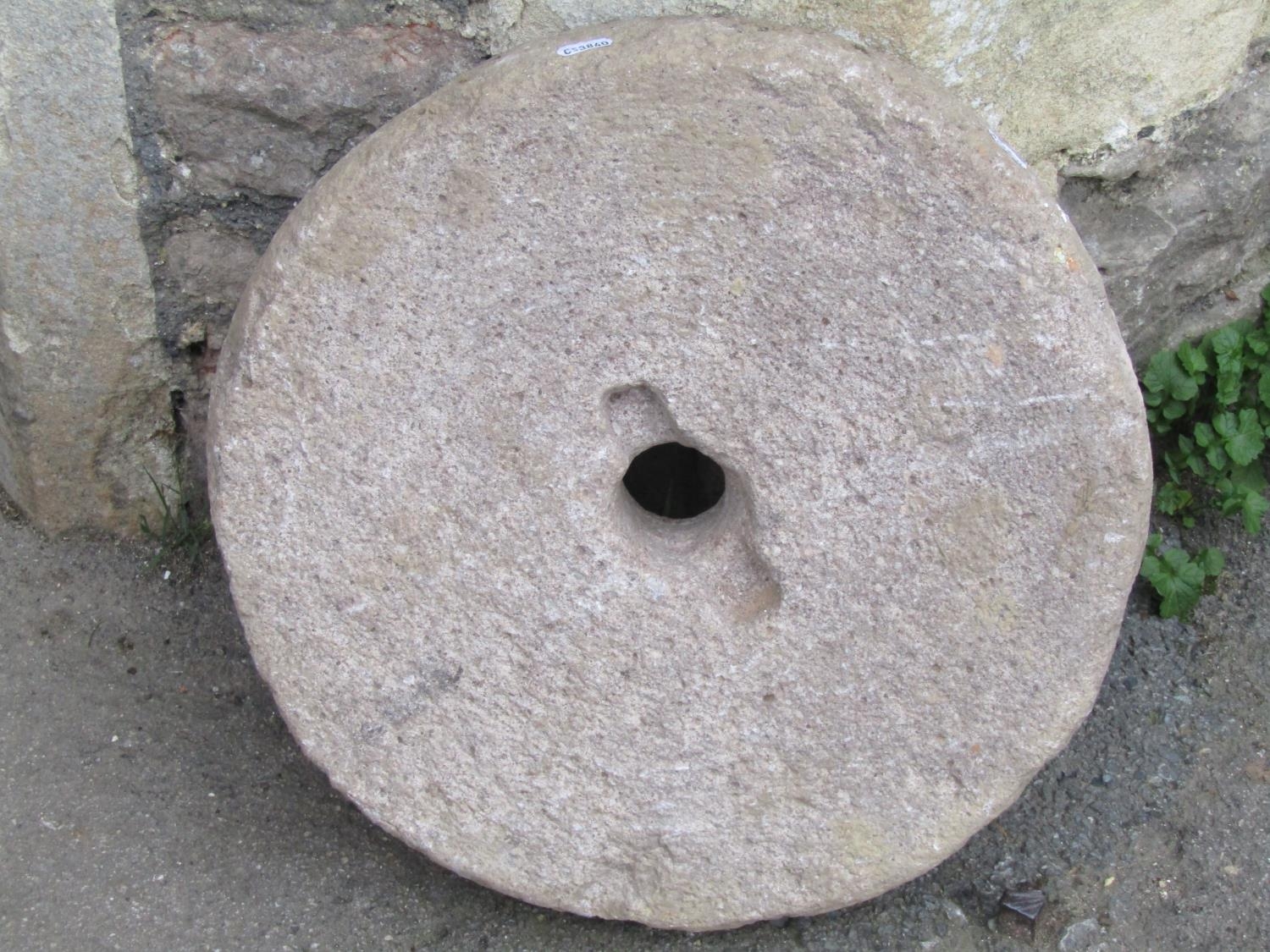 A carved stone mill/grinding wheel, 45 cm diameter