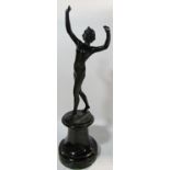 An early 20th century bronze statue of a naked female arms aloft , indistinctly signed, raised on
